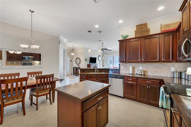 kitchen with ceiling fan, sink, hanging light fixtures, kitchen peninsula, and appliances with stainless steel finishes