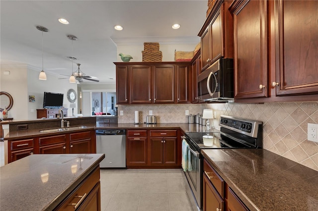 kitchen featuring tasteful backsplash, stainless steel appliances, sink, light tile patterned floors, and hanging light fixtures