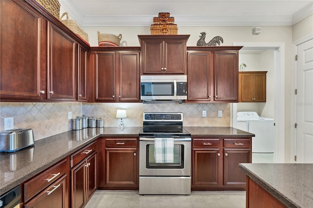 kitchen featuring washing machine and clothes dryer, tasteful backsplash, light tile patterned floors, and stainless steel appliances