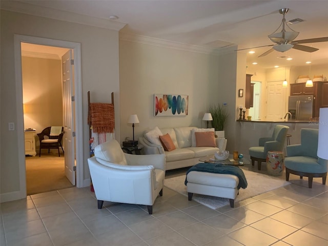 living room with crown molding, light tile patterned floors, and ceiling fan