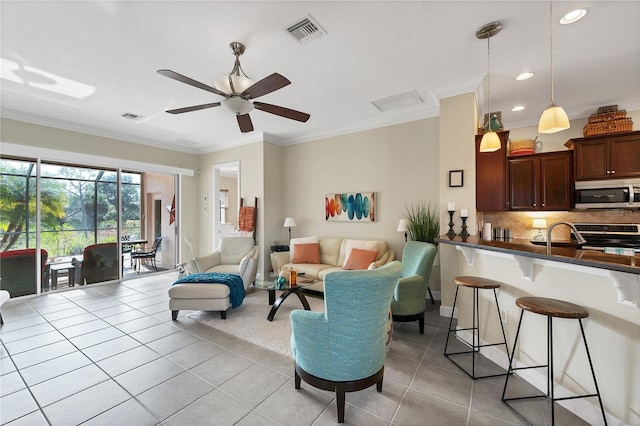 living room featuring crown molding, light tile patterned floors, and ceiling fan