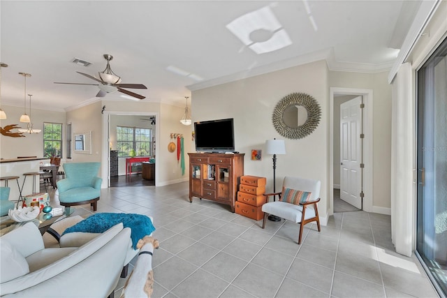 living room with light tile patterned floors, ceiling fan with notable chandelier, and ornamental molding