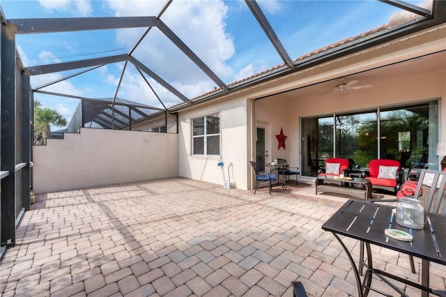 view of patio / terrace with an outdoor living space, ceiling fan, and a lanai