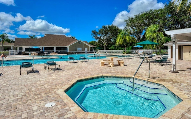 view of pool featuring a hot tub and a patio area