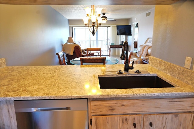 kitchen with light stone countertops, light brown cabinetry, a textured ceiling, sink, and a chandelier