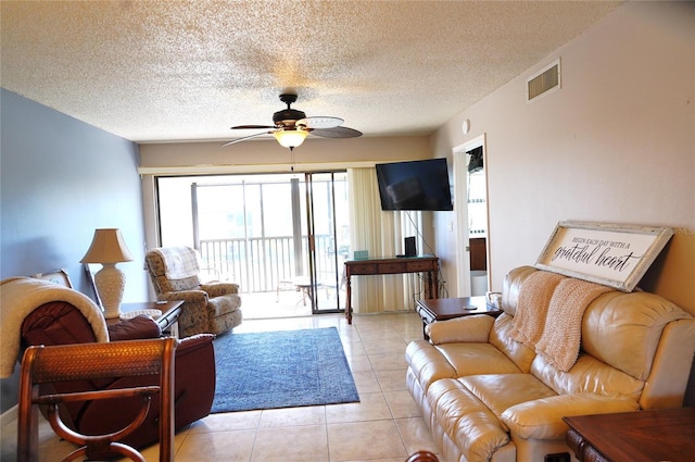 living room featuring a textured ceiling, ceiling fan, and light tile patterned flooring