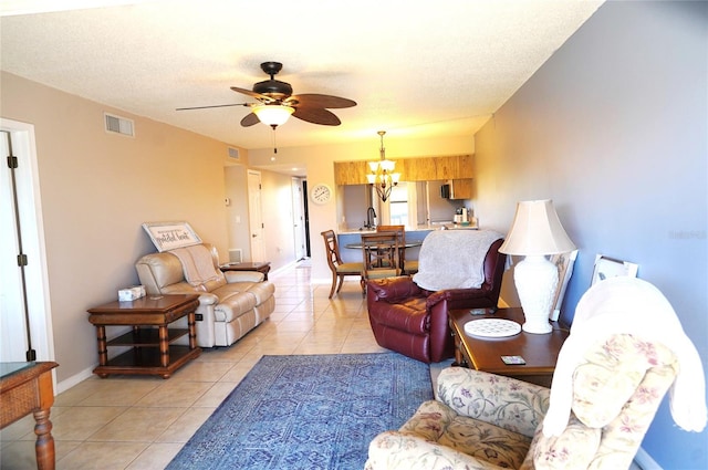 living room featuring light tile patterned floors, ceiling fan with notable chandelier, a textured ceiling, and sink