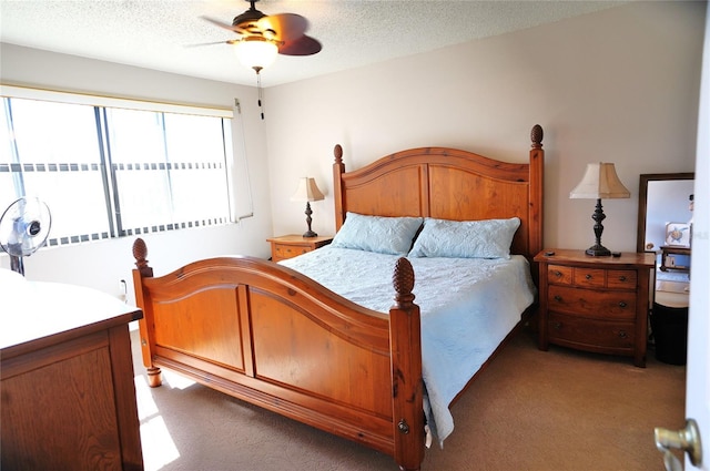 carpeted bedroom featuring ceiling fan and a textured ceiling