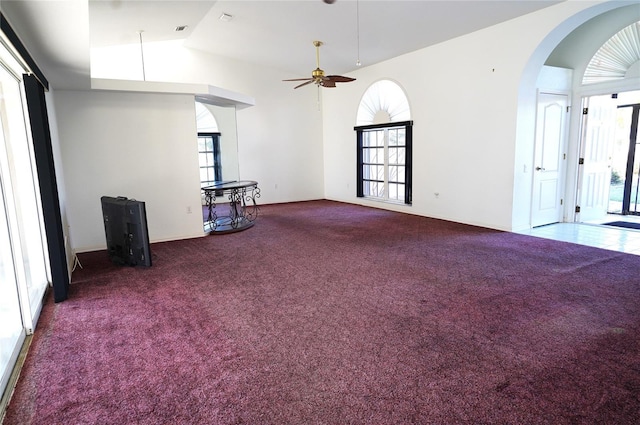 unfurnished living room with vaulted ceiling, ceiling fan, and carpet flooring