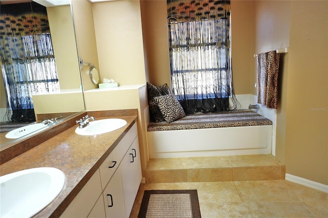 bathroom with vanity, a washtub, tile patterned flooring, and a wealth of natural light