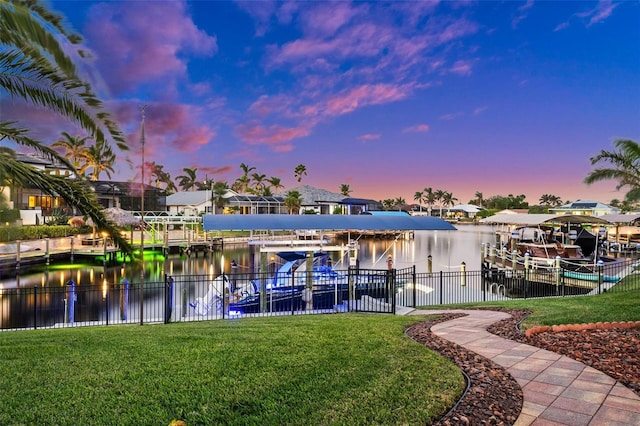 view of dock with a water view and a lawn