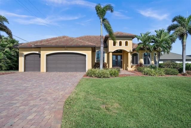 mediterranean / spanish-style home with french doors, a front yard, and a garage