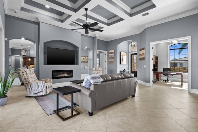 tiled living room with coffered ceiling, ceiling fan, crown molding, beamed ceiling, and a high ceiling