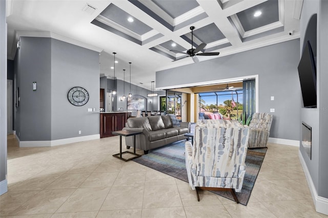 tiled living room featuring crown molding, beamed ceiling, ceiling fan, and coffered ceiling