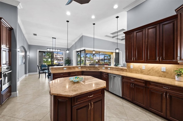 kitchen with kitchen peninsula, ornamental molding, stainless steel appliances, a center island, and hanging light fixtures