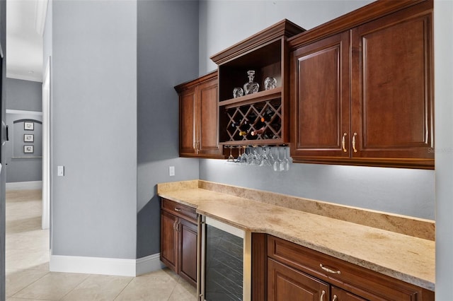 bar featuring light stone countertops, light tile patterned floors, and beverage cooler