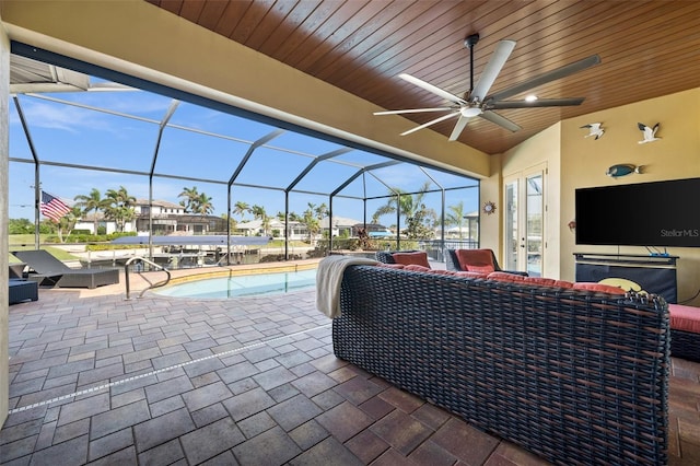 view of patio / terrace featuring glass enclosure, ceiling fan, and an outdoor living space