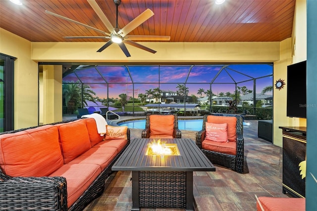 view of patio featuring ceiling fan, an outdoor living space, and glass enclosure