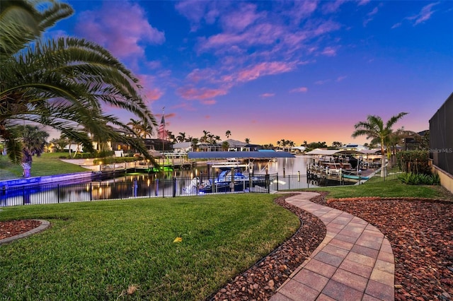 dock area with a yard and a water view