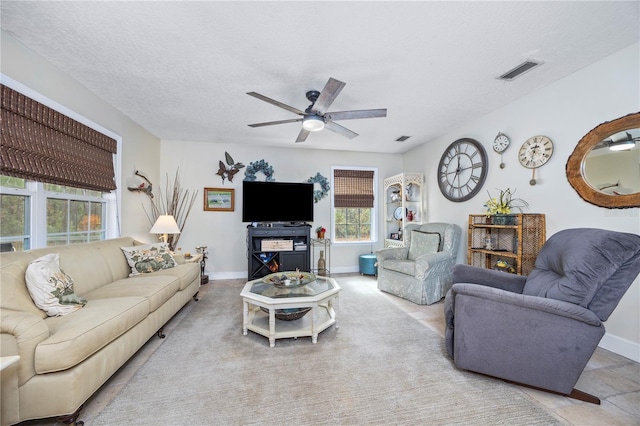 living room with ceiling fan and a textured ceiling