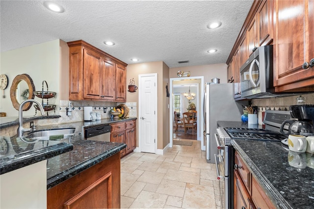 kitchen with sink, appliances with stainless steel finishes, tasteful backsplash, a textured ceiling, and dark stone counters