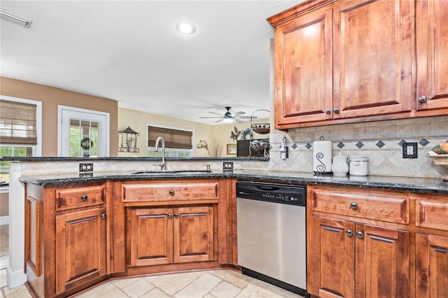 kitchen featuring sink, dark stone countertops, decorative backsplash, stainless steel dishwasher, and kitchen peninsula