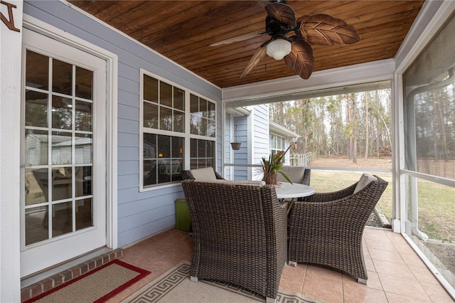 sunroom with ceiling fan, a healthy amount of sunlight, and wooden ceiling