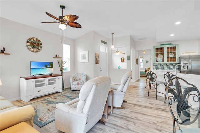 living room featuring light wood-type flooring and ceiling fan