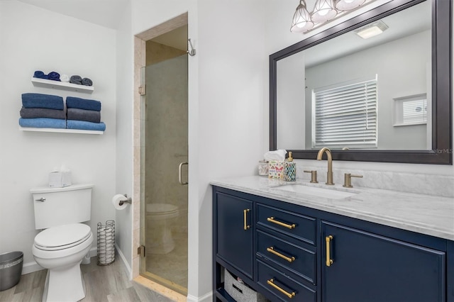 bathroom featuring hardwood / wood-style floors, an enclosed shower, vanity, and toilet