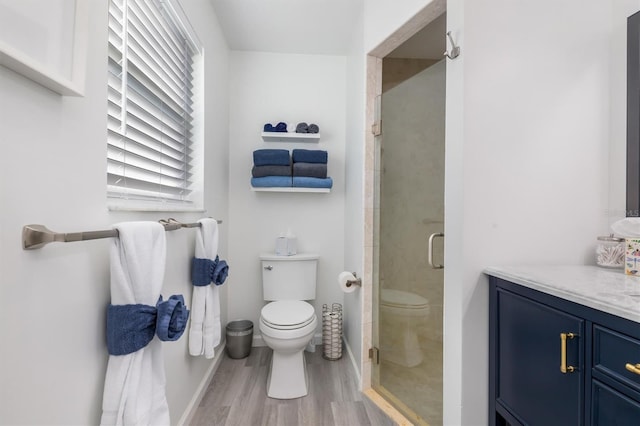 bathroom with toilet, a shower with door, vanity, and hardwood / wood-style floors