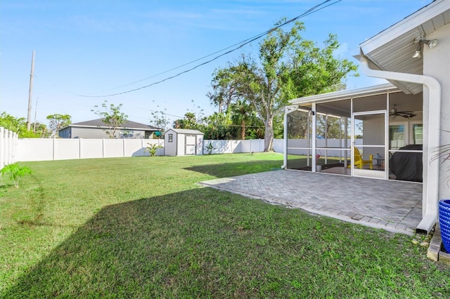 view of yard featuring a patio, a sunroom, and a shed