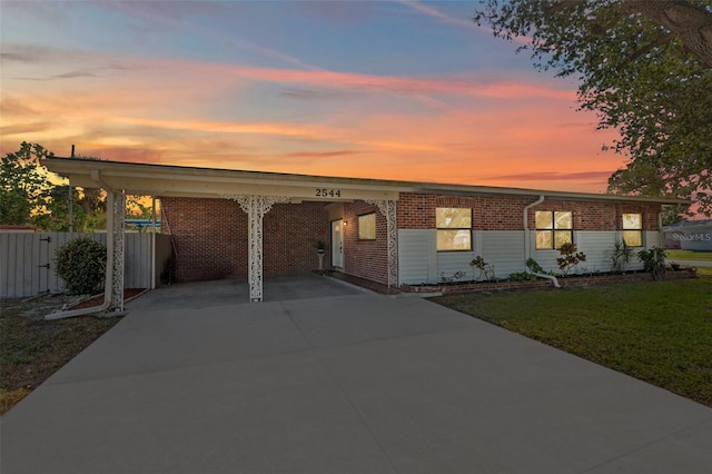 view of front of home featuring a carport and a lawn