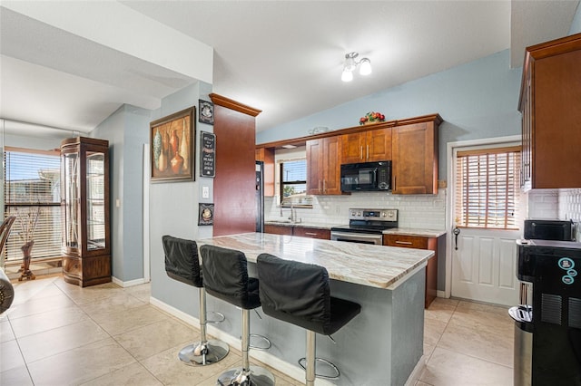 kitchen featuring a kitchen bar, electric stove, decorative backsplash, and vaulted ceiling