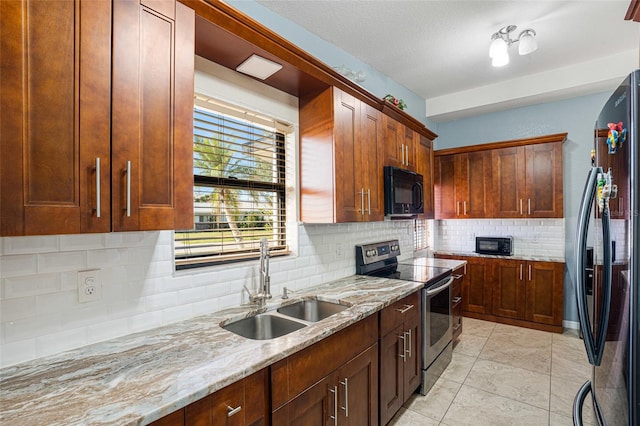 kitchen with light stone countertops, sink, decorative backsplash, light tile patterned flooring, and appliances with stainless steel finishes