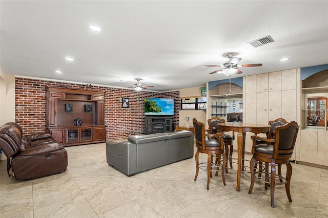 living room featuring a textured ceiling and brick wall