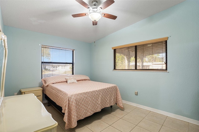 tiled bedroom with ceiling fan and vaulted ceiling