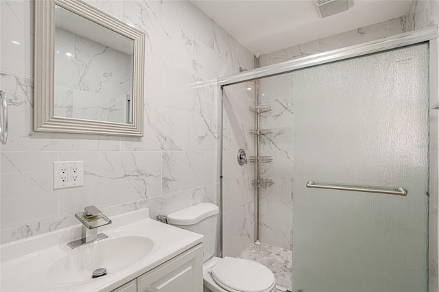 bathroom featuring vanity, toilet, tile walls, and a shower with shower door