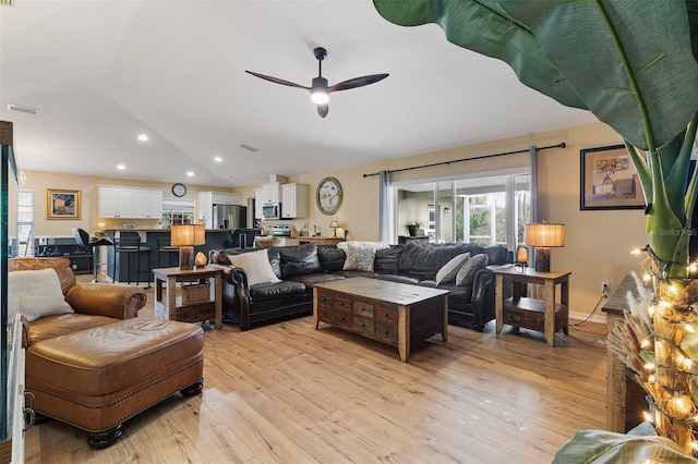 living room featuring lofted ceiling, ceiling fan, and light hardwood / wood-style floors