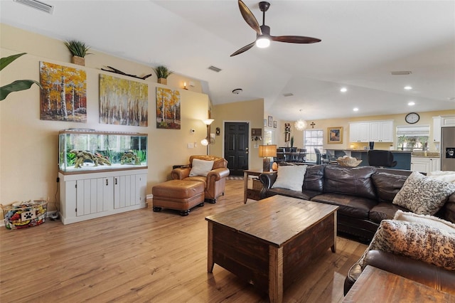 living room with ceiling fan, light hardwood / wood-style flooring, and vaulted ceiling