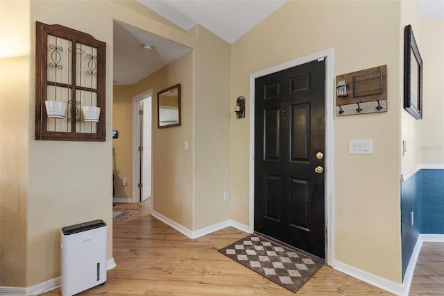 entrance foyer featuring lofted ceiling and light hardwood / wood-style floors