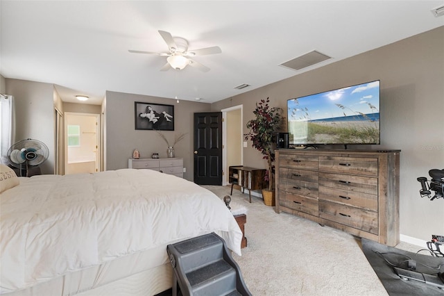 carpeted bedroom with ensuite bathroom and ceiling fan