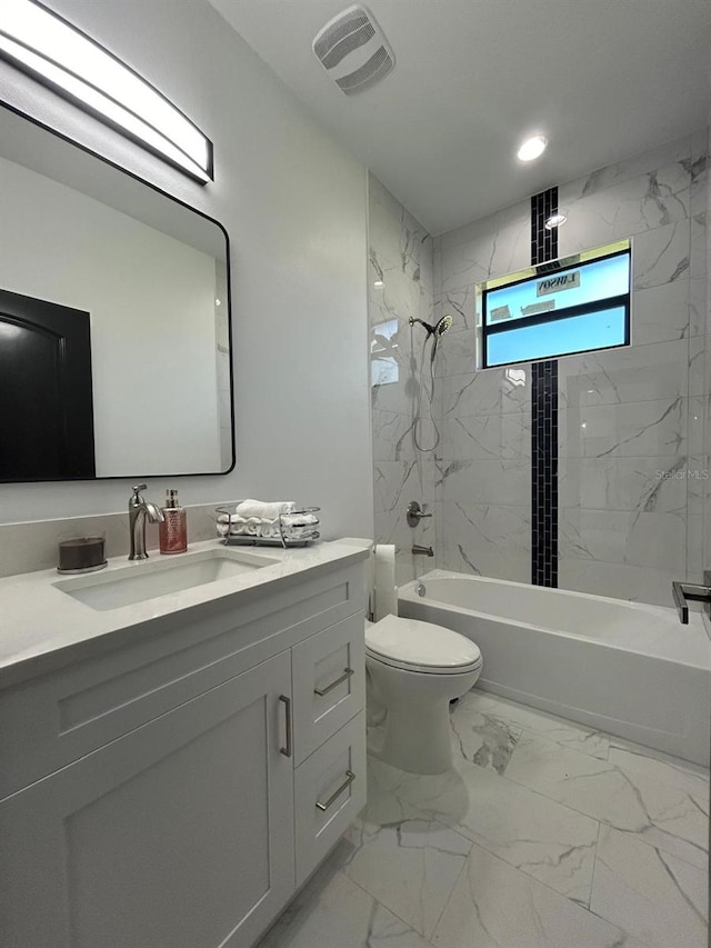 full bathroom with vanity, tiled shower / bath combo, and toilet