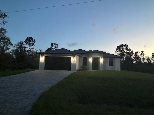 view of front of house featuring a garage and a yard