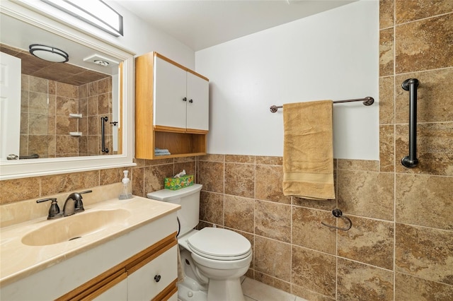 bathroom with toilet, vanity, and tile walls