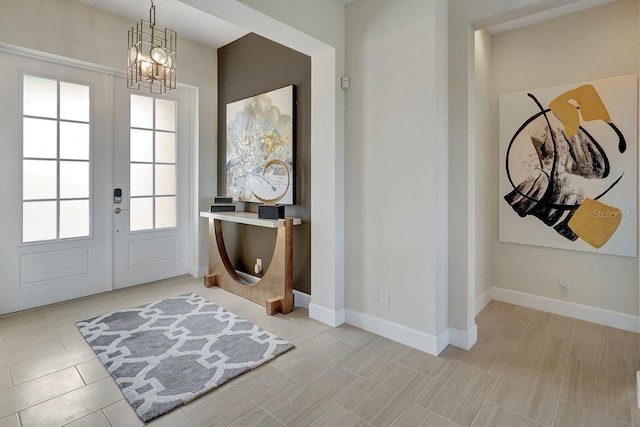 foyer featuring an inviting chandelier and french doors