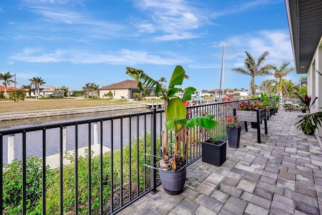 view of patio / terrace featuring a water view and a balcony