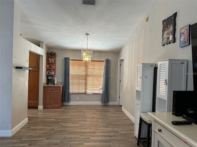 kitchen with a chandelier, hanging light fixtures, and dark hardwood / wood-style floors