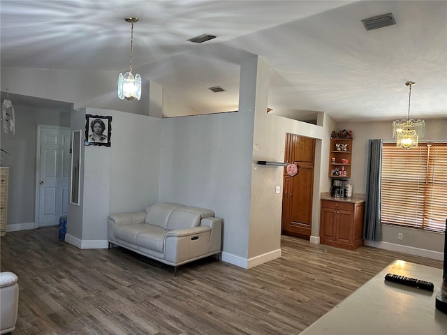 interior space featuring a notable chandelier, vaulted ceiling, and dark hardwood / wood-style floors