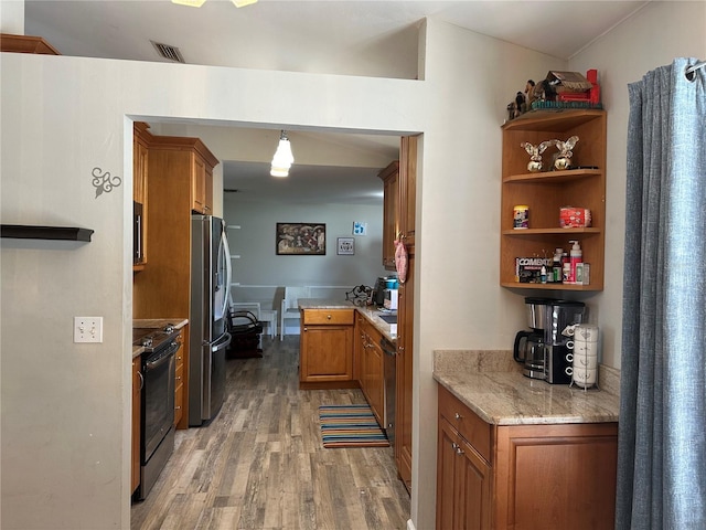 kitchen with stainless steel refrigerator, wood-type flooring, electric range, and hanging light fixtures