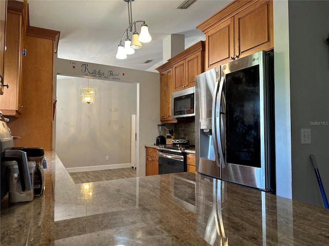 kitchen with a notable chandelier, backsplash, hanging light fixtures, and appliances with stainless steel finishes